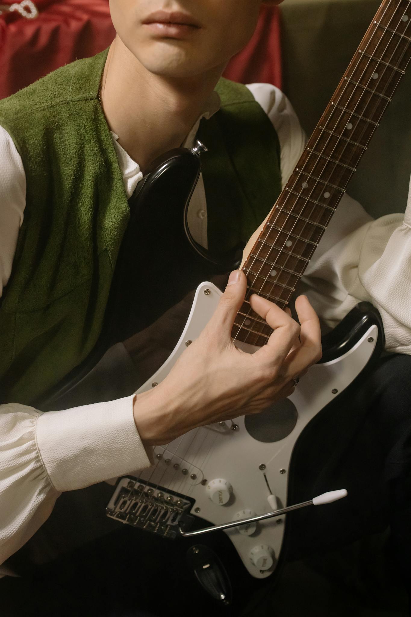 Close-up view of a musician playing an electric guitar indoors.